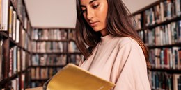 Woman reading a book at a library