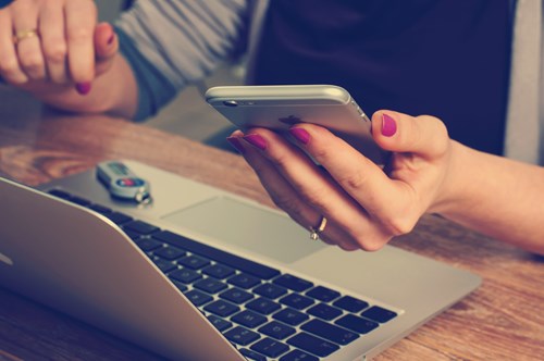 Student using her phone and laptop