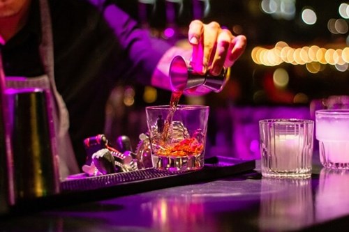 Bartender pouring a drink in a glass