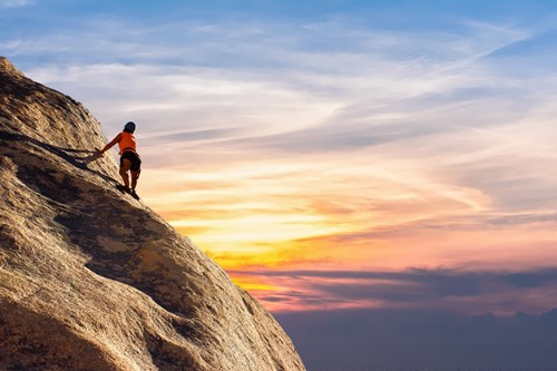 Young woman climbing a cliff