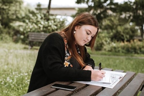 Student working on an essay in a park
