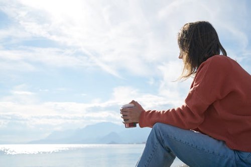 Student having a coffee by the sea