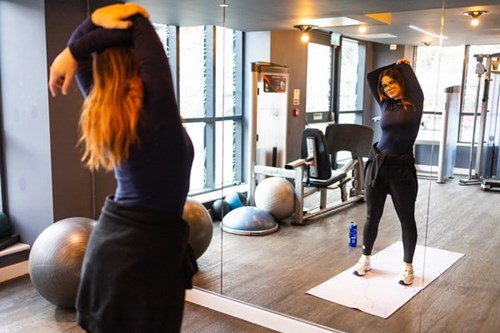 A student exercising in front of a mirror