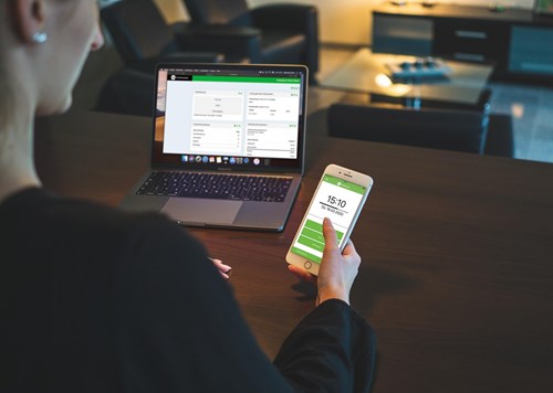 a person checking the time on their phone using a laptop