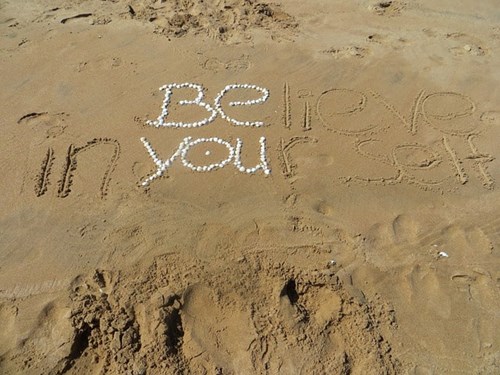 Be yourself written on a beach