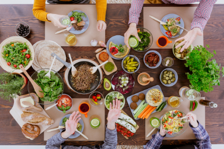 Four people sitting round a table with plates of food