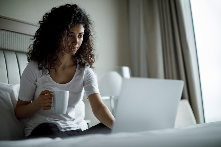 Young woman using her laptop on the bed